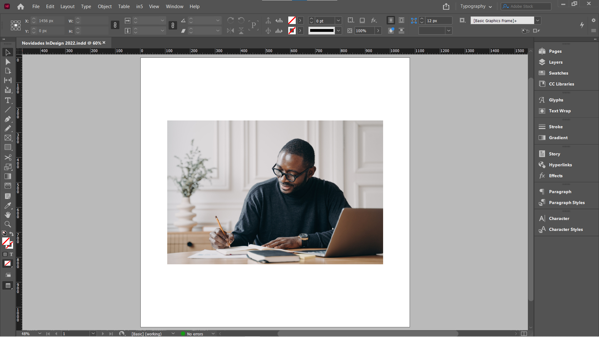 Imagem que mostra a interface do InDesign, com uma fotografia de um homem sentado à mesa, com um computador e escrevendo em um caderno, com as dimensões “small” e “large” acionadas.