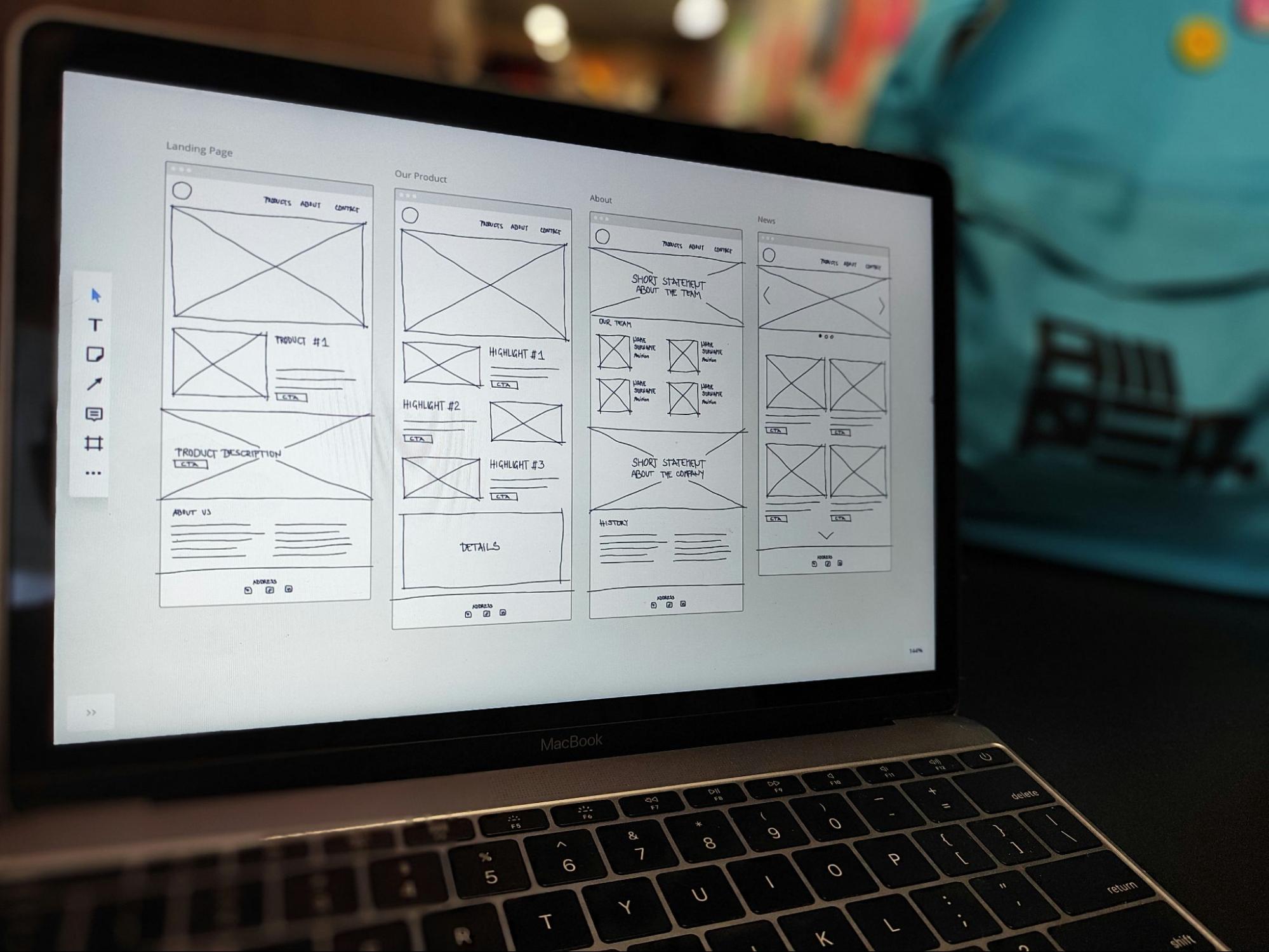 Tela de um laptop com a tela aberta, exibindo wireframes de um aplicativo mobile em desenvolvimento.