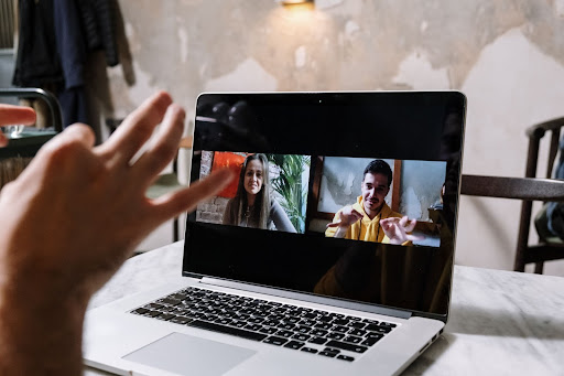 Três pessoas em uma videoconferência pelo notebook.