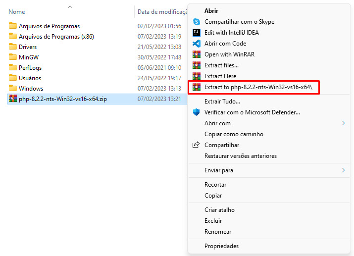 Imagem do mesmo print anterior, que mostra a tela do Disco Local (C:), com destaque para o arquivo compactado “php-8.2.2-nts-Win32-vs16-x64”. A imagem mostra a seleção deste arquivo. Ao clicar com o botão direito do mouse, é mostrada uma aba com opções. Em destaque vermelho, há a opção que devemos clicar “Extract to php-8.2.2-nts-Win32-vs16-x64”.