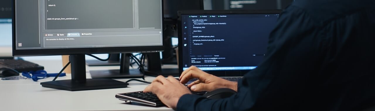 homem digitando em um computador. Na tela, códigos, representando soluções com IA